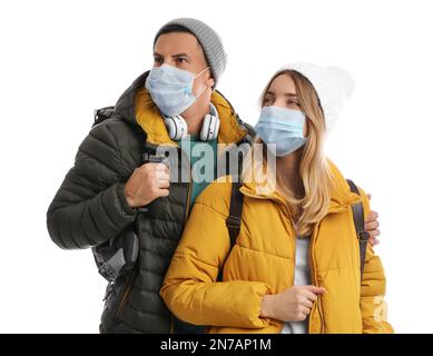 Couple in face masks and warm clothes on white background. Winter ...