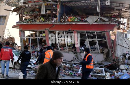 Antakya, Turkey. 10th Feb, 2023. People walk past a damaged building in Antakya, Hatay province, T¨¹rkiye, on Feb. 10, 2023. The death toll from Monday's devastating earthquakes climbed to 20,213 in T¨¹rkiye, while another 80,052 injuries were reported in the country, Turkish Health Minister Fahrettin Koca announced late Friday. Credit: Shadati/Xinhua/Alamy Live News Stock Photo