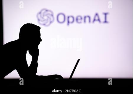 UK, LONDON. JANUARY 30, 2023: The Future of Technology in the Palm of His Hand: Silhouette of Man with AI Software Logo Stock Photo