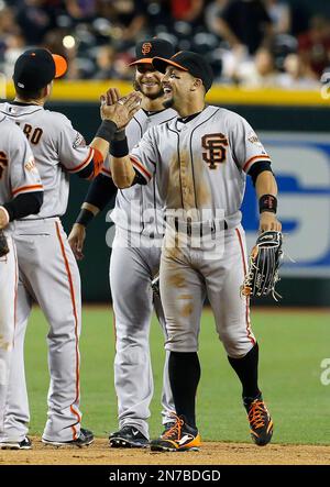 The Giants' Marco Scutaro, (left) Brandon Crawford, (35) Angel Pagan, (16),  and Andres Torres, (behind) celebrate Pagan's winning run with an inside  the park homer in the tenth inning as the San
