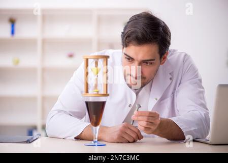 Young chemist examining soft drink at the lab Stock Photo