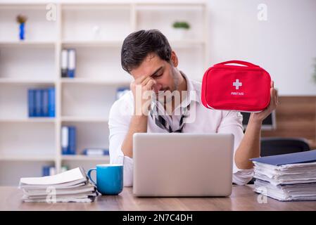 Young businessman employee feeling bad at workplace Stock Photo
