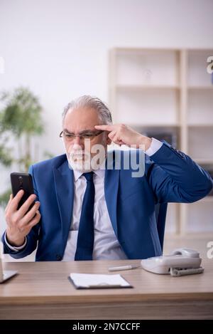 Old boss working in the office Stock Photo