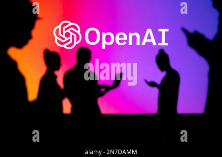 INDIA, NEW DELHI. JANUARY 30, 2023: Open AI. Collaborating for Innovation: Silhouetted Web Developers in Action with Company Logo in Background Stock Photo