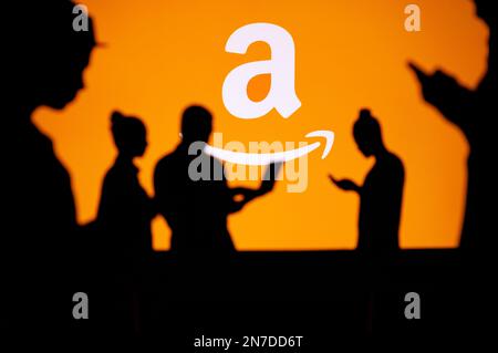 USA, WASHINGTON, JANUARY 30, 2023: Amazon. Web Development Dreams Come True: Silhouetted Developers in Discussion with Company Logo Stock Photo