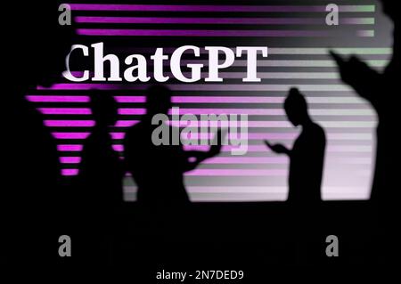 JAPAN, TOKYO. JANUARY 30, 2023: ChatGPT. Collaborating for Innovation: Silhouetted Web Developers in Action with Company Logo in Background Stock Photo