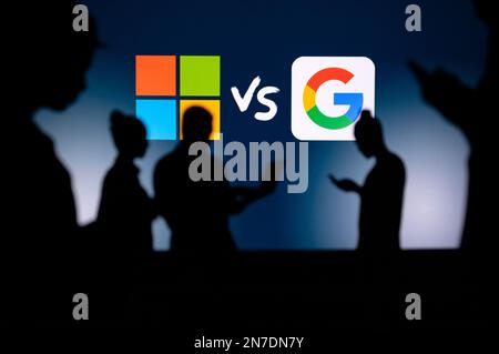 UK, LONDON. JANUARY 30, 2023: Microsoft vs Google. Innovating Together: Silhouetted Web Developers Uniting for Progress with Company Logo in Backgroun Stock Photo