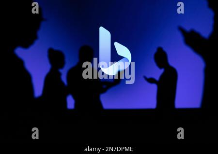 JAPAN, TOKYO. JANUARY 30, 2023: Bing Collaborating for Innovation: Silhouetted Web Developers in Action with Company Logo in Background Stock Photo