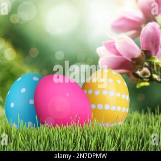 Bright Easter eggs on green grass outdoors Stock Photo
