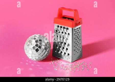 Grater and silver disco party ball on pink background Stock Photo