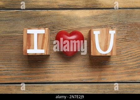 Phrase I Love You made of cubes with letters and heart on wooden table, flat lay Stock Photo