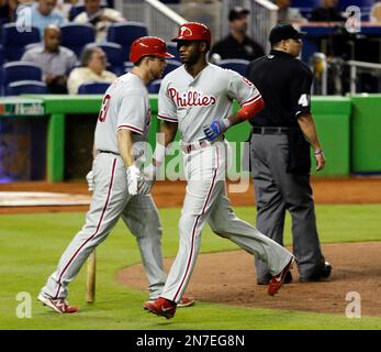 Philadelphia Phillies' Domonic Brown is congratulated in the dugout after  scoring on a single hit by Jerad Eickhoff in the fourth inning of a  baseball game against the Miami Marlins, Friday, Aug.