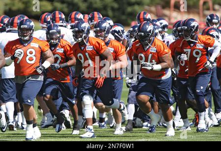 Denver Broncos players run on the field led by McTelvin Agim (95), Marquiss  Spencer (51), Justin Strnad (40), Jamar Johnson (41) with other following  to start an NFL football preseason game against