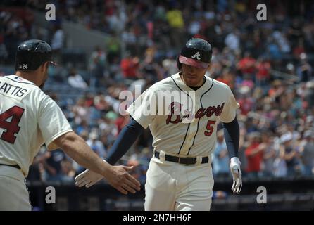 Atlanta Braves' Freddie Freeman is congratulated in the dugout after  scoring on Nick Markakis' groundout to second base during the first inning  of a baseball game against the Philadelphia Phillies, Sunday, June