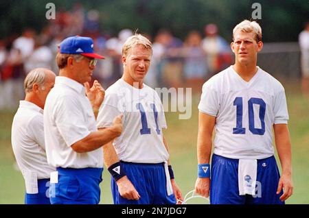 New York Giants quarterback Phil Simms (11) and Kent Graham (10) watch head  coach Dan Reeves, left, signal, in a play during morning practice at  training camp in Madison, N.J. Aug. 13