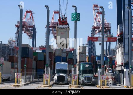 A large crane lifts shipping containers onto trucks at the Long Beach Container Terminal (LBCT). The LBCT $2.5 billion investment that has enabled one of the world's top port terminal operators to significantly reduce emissions and have “net zero” within its grasp. This tour will also reveal for the first time more details of a $30 million project at LBCT to deploy zero-emission cargo handling equipment and an exclusive look at LBCT's plans to fully decarbonize operations by 2030. (Photo by Ringo Chiu/SOPA Images/Sipa USA) Stock Photo