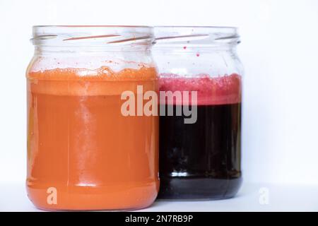 freshly squeezed carrot and beetroot juice in banks on a table in the morning Stock Photo