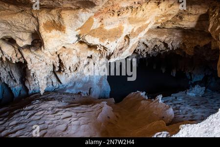 Inside interior of a large underground cave cavern with calcite stalactites hanging from the ceiling Stock Photo