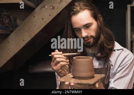 pottery man master work painting clay cup. handcraft pot artist maker with care. Stock Photo