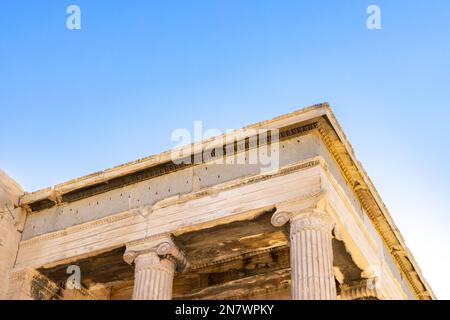 Sun hiding behind the columns of the Parthenon temple at Acropolis site on a sunny evening in Athens Greece Stock Photo