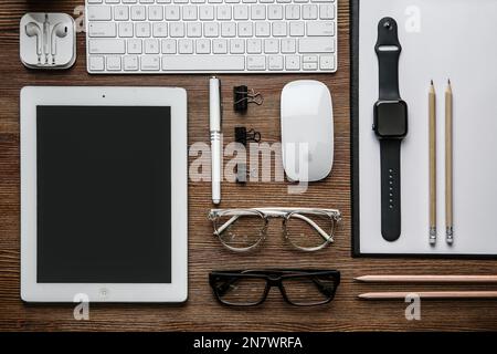 MYKOLAIV, UKRAINE - JULY 20, 2020: Flat lay composition with different Apple gadgets on wooden table Stock Photo
