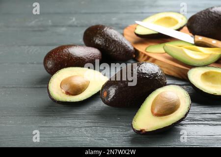 Whole and cut avocados on grey table, closeup Stock Photo - Alamy