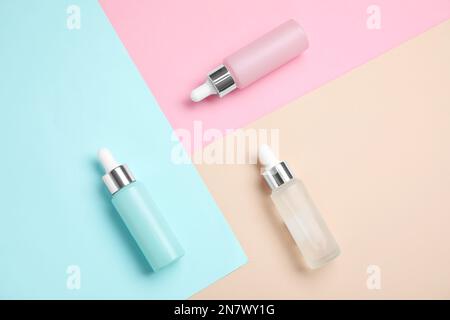 Bottles of essential oils on color background, flat lay Stock Photo