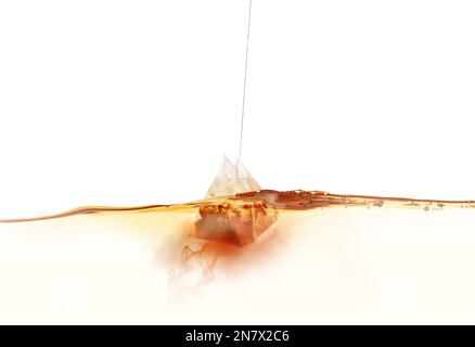 Dipping of tea bag into hot water against white background Stock Photo