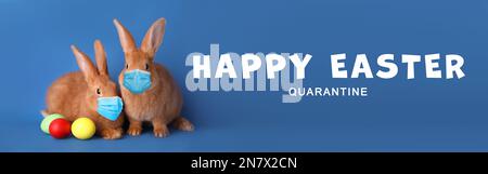 Text Happy Easter Quarantine and cute bunnies in protective masks on blue background, banner design. Holiday during Covid-19 pandemic Stock Photo