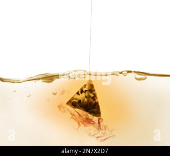 Dipping of tea bag into hot water against white background Stock Photo