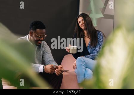 A gorgeous caucasian businesswoman is listening and laughing to her black boyfriend while having a fun conversation Stock Photo