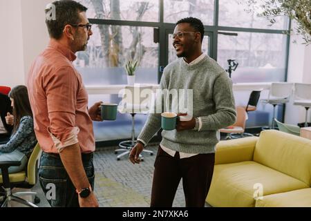 Two diverse coworkers making a plan for their next client on the internet at the office Stock Photo