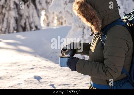 https://l450v.alamy.com/450v/2n7ykje/hiker-pouring-hot-drink-from-thermos-into-travel-mug-refreshment-during-winter-trekking-in-cold-weather-2n7ykje.jpg