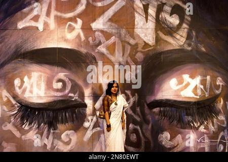 dhaka dhaka bangladesh 11th feb 2023 a woman poses in front of an artwork reetu by bishwajit goswami during dhaka art summit at national art gallery in dhaka bangladesh written in bengali across the face the word reetu meaning seasons is also a commonly used first name for bengali girls culturally and symbolically related to the name bonna flood which is the theme of dhaka art summit bangladesh has six seasons and some would argue had as climate change has made two seasons difficult to recognize anymore each harkening to a particular mood fee 2n80ewt