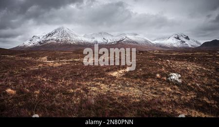 Isle of Skye, Scotland - Panoramic view of the snowy mountains of Glamaig on a cloudy spring day on Isle of Skye at the Scottish Highlands with cloudy Stock Photo