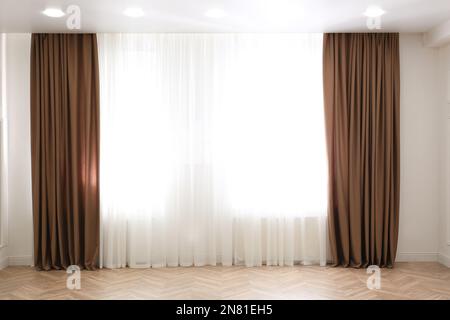 Windows with elegant curtains in modern room Stock Photo