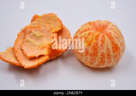 Ripe peeled orange tangerine, sweet fruit with orange skin located on a white background in different positions. Stock Photo