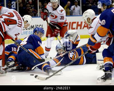 As New York Islanders defenseman Jeff Norton, left, skates by, the  Washington Capitals surround teammate Dale Hunter, (32) after Hunter scored  the Capitals' first goal of the night in the third period