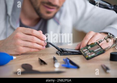 man is repairing broken pc with a screw driver Stock Photo