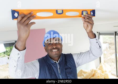 laborer holding a level on the ceiling Stock Photo