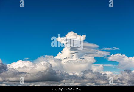 A dramatic thunderhead or cumulonimbus cloud forming against a deep blue sky (Sicily, Italy) Stock Photo