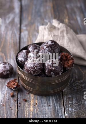 Soft vegan steamed chocolate gingerbread cookies with icing sugar in vintage bowl on wooden table Stock Photo