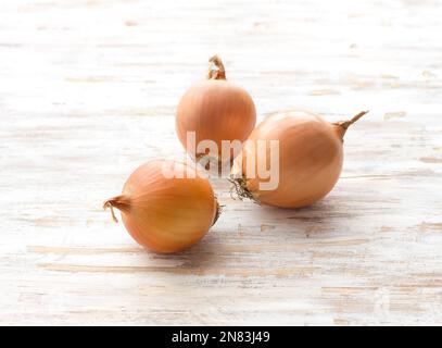 Onions on a light wooden background, selective focus, horizontal Stock Photo