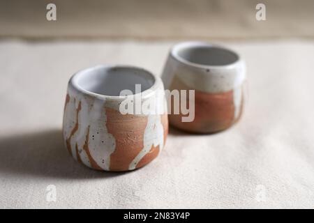 Handmade empty craft ceramic on  textile background. Stock Photo