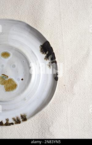 Handmade empty craft ceramic on  textile background. Stock Photo