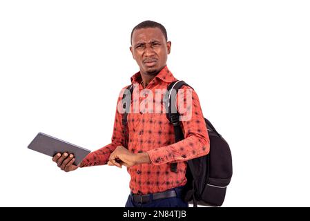young disgruntled student man with backpack holding digital tablet Stock Photo