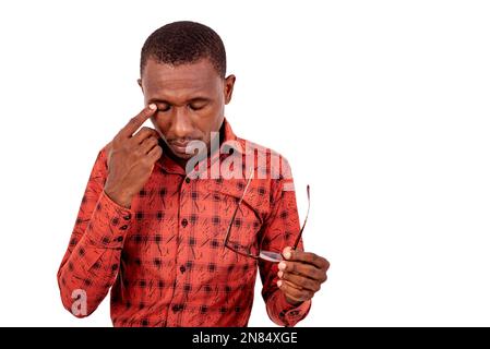 a handsome man in checkered shirt standing over white background holding eyeglasses while thinking. Stock Photo