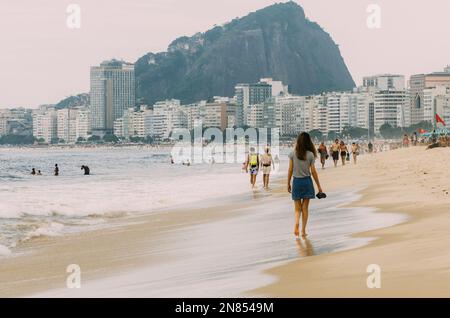 Rio de Janeiro, Brazil - February 7, 2023: People at Copacabana beach in Rio de Janeiro, Brazil on a cloudy day Stock Photo