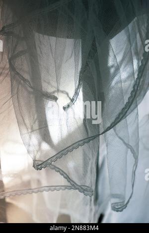 Delicate, airy tulle with a lace border falls smoothly over a high table and shimmers in red and turquoise. Stock Photo