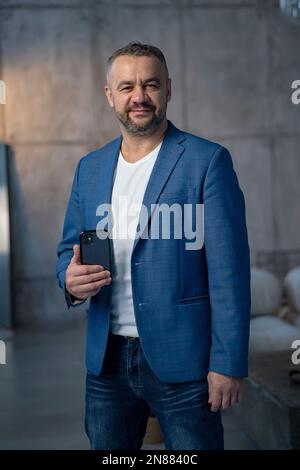 Excited happy young indian man winner feeling joy using smartphone winning lottery game, betting, getting cashback online gift in mobile app message Stock Photo